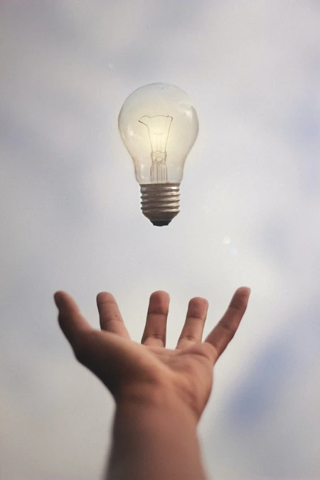 lightbulb floating above hand