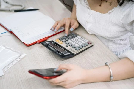 Women trying to calculate investment loan using her phone and calculator.
