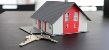 Miniature house with keys next to it