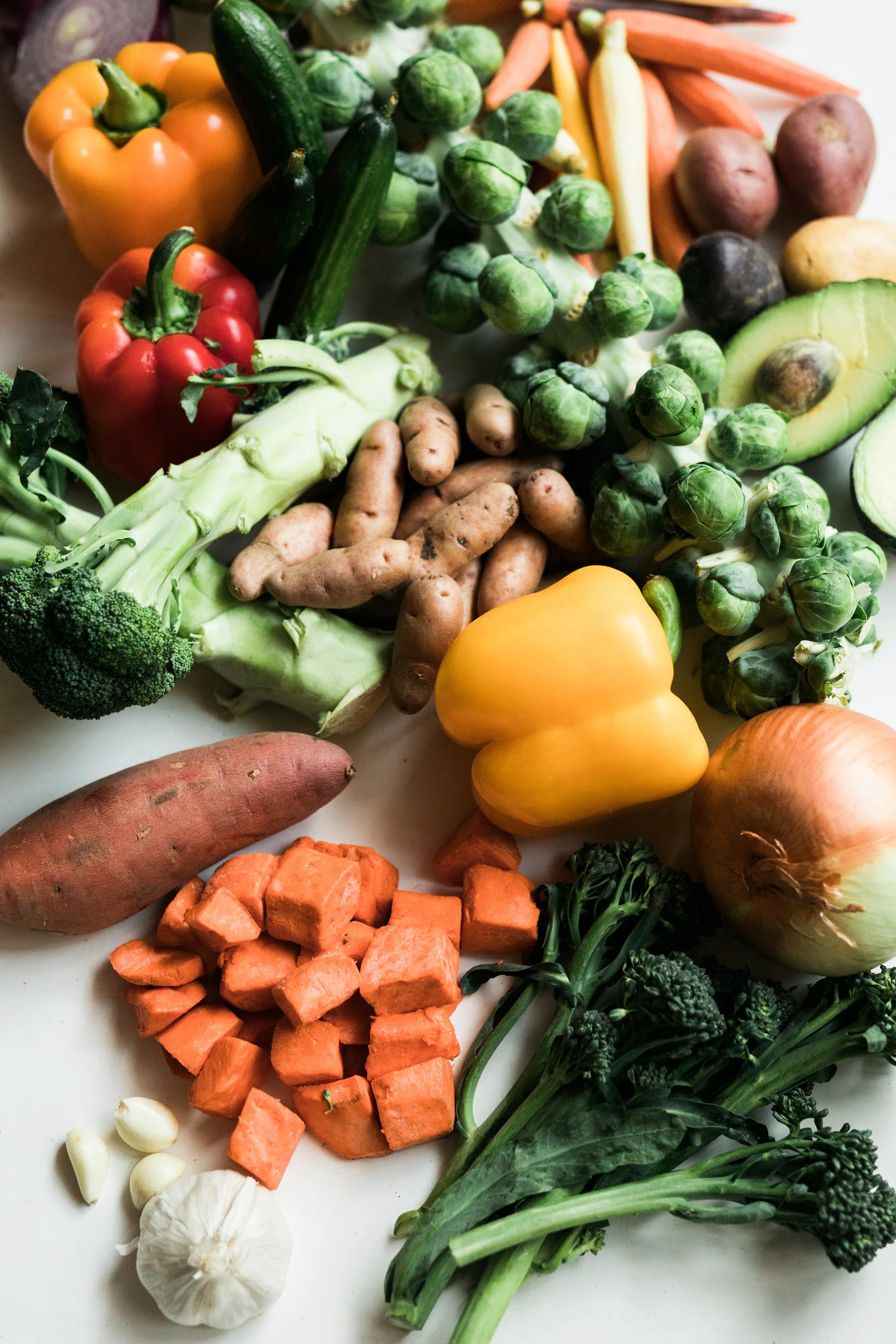 variety of mixed vegetables, including peppers, onions, broccoli, garlic, and avocado